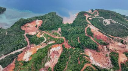 Aktivitas pertambangan nikel di Pulau Kabaena, Kabupaten Bombana, Sulawesi Tenggara, tampak dari udara dengan area hutan terbuka dan sedimentasi yang mengalir ke pesisir laut.