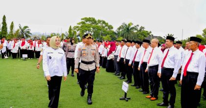 Wali Kota Kendari Siska Karina Imran berjalan bersama pejabat kepolisian saat pengukuhan RT dan RW se-Kota Kendari, dengan para ketua RT/RW berbaris rapi di lapangan.