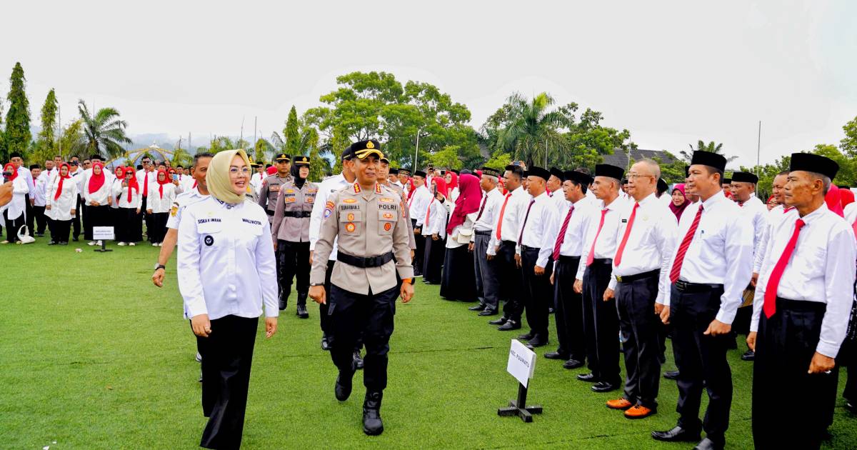 Wali Kota Kendari Siska Karina Imran berjalan bersama pejabat kepolisian saat pengukuhan RT dan RW se-Kota Kendari, dengan para ketua RT/RW berbaris rapi di lapangan.