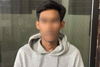 Terduga pelaku pencurian laptop Sekolah Rakyat di Kendari mengenakan hoodie abu-abu saat diamankan oleh Satreskrim Polresta Kendari, dengan wajah disamarkan.